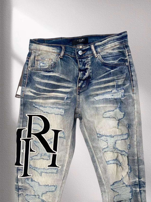 AMIRI Distressed Patchwork Logo Jeans – Light Blue Wash