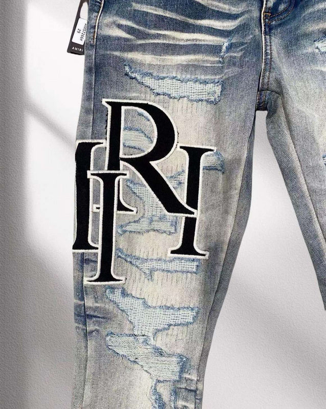 AMIRI Distressed Patchwork Logo Jeans – Light Blue Wash