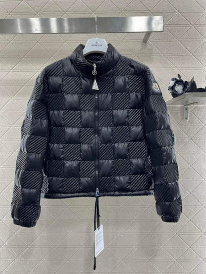 Black quilted jacket with brand tag on a tiled wall