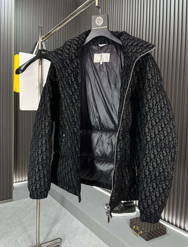 Black textured jacket on a hanger against a neutral background