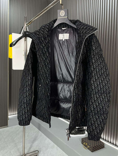 Black textured jacket on a hanger against a neutral background